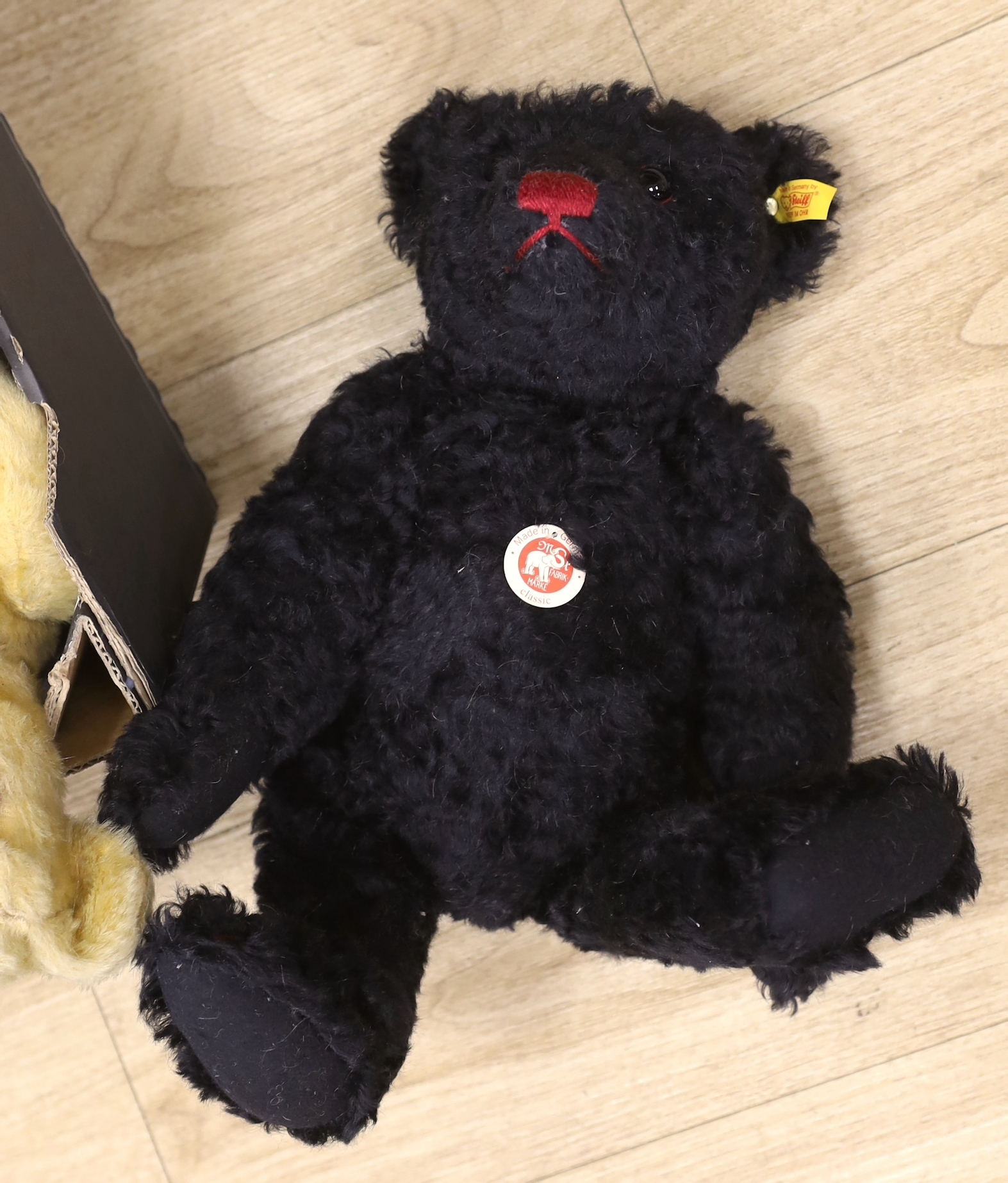 A collection of vintage and later teddy bears, some with articulated limbs, including a modern Steiff example with growler together with a seated dog, the largest 60cm in length